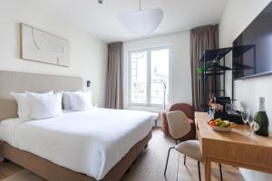 a hotel room with a large bed and a desk at Le Catherine by Sweett in Brussels