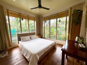a bedroom with a bed and a ceiling fan at Vrindavan homestay in Munroe Island