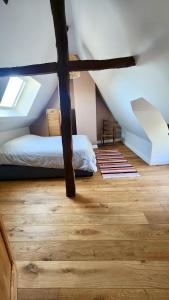 een zolderkamer met 2 bedden en een houten vloer bij Détente Famille Charme Normand - Maison de charme - Proche mer et plages in La Gaillarde