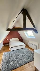 een slaapkamer op zolder met een bed en een raam bij Détente Famille Charme Normand - Maison de charme - Proche mer et plages in La Gaillarde