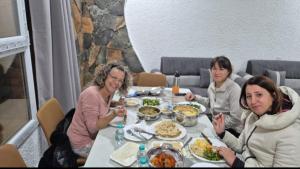 a group of women sitting at a table eating food at Climbing Guest House Jebel Shams in Dār Sawdāʼ
