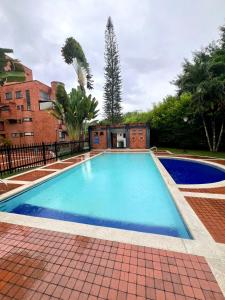 Una piscina con agua azul en un patio. en Apto Multicentro Cali | Piscina, Home Office, 2HB, en Cali