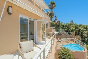 a balcony with a chair and a swimming pool at Ocean Villa Views Fish Hoek in Glencairn