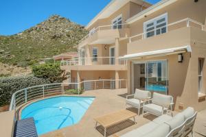 a villa with a swimming pool and a house at Ocean Villa Views Fish Hoek in Glencairn