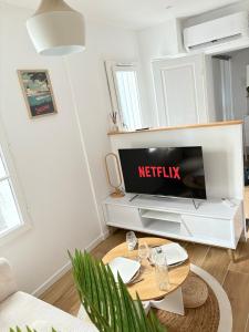 een woonkamer met een tv en een tafel bij L'impasse Japandi in Libourne