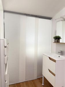 een keuken met een schuifdeur, een spoelbak en een koelkast bij L'impasse Japandi in Libourne