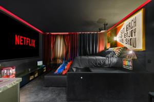 a living room with a couch and a television at YourSuite Studio Premium à Thème in Chaville