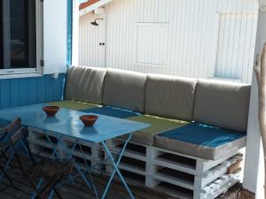 Cabana de Praia no centro de Lisboa في كاباريكا: أريكة على شرفة مع طاولة