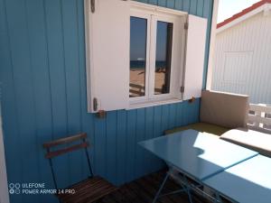 Cabana de Praia no centro de Lisboa في كاباريكا: طاولة ونافذة في غرفة مطلة على الشاطئ