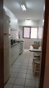 una cocina con electrodomésticos blancos, mesa y sillas en Residencial Gabriela, en Itapema