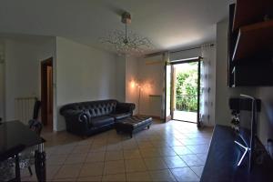 a living room with a leather couch and a chandelier at Casa DiVa in Terni