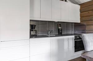 a kitchen with white cabinets and a sink at Vikinggrenda 16A by Vacation Trysil in Trysil +8 photos