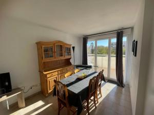 a dining room with a table and chairs and a window at Appartement moderne à Fréjus, 60 m², piscine partagée in Fréjus
