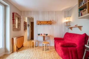 a living room with a red couch and a table at Studio Chaleureux, Plein Sud in Villard-de-Lans +18 photos