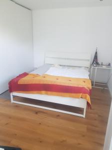 Im Alpennest في Niederdorla: سرير في غرفة مع أرضية خشبية