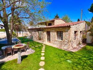 a small stone house with a table and a yard at Lacosse in Le Grau-dʼAgde