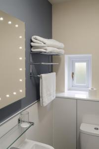 een badkamer met een wastafel, een toilet en handdoeken bij Lochmaddy Hotel in Lochmaddy