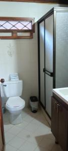a bathroom with a toilet and a glass shower at Chalet Completo para Familias Condominio Campestre Privado con Piscinas, wifi, AC in Santa Marta