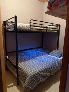 a bunk bed with a blue and white striped mattress at Appartement 5 pers - Draps et serviettes inclus in La Lechere