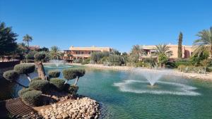 a fountain in the middle of a pool of water at Chic Palm Grove Apartment Pool View in Marrakesh