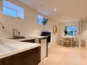 a kitchen with a sink and a dining room with a table at Soft Stay Apartment in Bergen