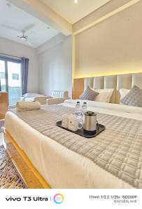 a hotel room with a bed with a tray on it at Vilaasitaa Family Suites in Indore