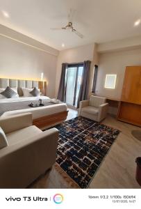 um quarto com uma cama, um sofá e um tapete em Vilaasitaa Family Suites em Indore