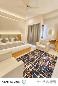 a bedroom with a bed and a couch and a rug at Vilaasitaa Family Suites in Indore
