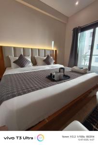 a bedroom with a large white bed with a tray on it at Vilaasitaa Family Suites in Indore
