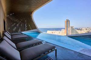 a pool on the roof of a building with a view at Luxury 360 Sea View 27th Floor Apartment in Mercury Tower in St. Julianʼs