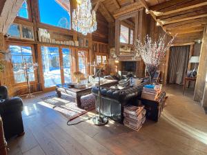 un soggiorno con un divano e un lampadario di Chalet Hermine a Megève