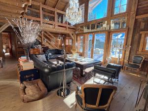 un soggiorno con un divano in pelle e un tavolo di Chalet Hermine a Megève Altre 50 foto
