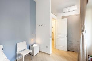 Nanninella Guest House في مينوري: غرفة نوم صغيرة بها كرسي أبيض وباب أبيض