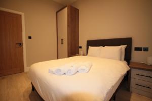 a bedroom with a bed with two towels on it at One Bedroom Flat With Free parking in Acton in London