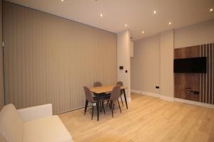 a dining room with a table and chairs and a flat screen tv at One Bedroom Flat With Free parking in Acton in London
