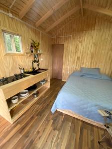 a bedroom with a bed in a wooden room at Cabaña Caiquen in Villa Cerro Castillo