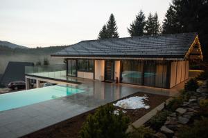 a house with a swimming pool in front of it at Berryhouse in Vyshkiv