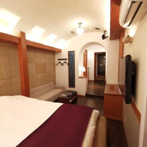 a hotel room with a bed and a couch at ホテル マリオン 鈴鹿 in Suzuka +30 photos