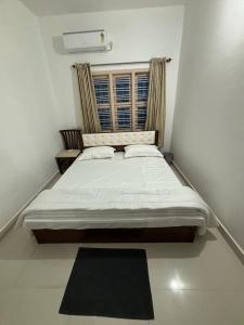 Comforts suites HVR في Sringeri: غرفة نوم بسرير كبير مع نافذة