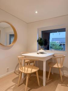 Un comedor con una mesa y sillas blancas. en New modern apartment, en Bergen