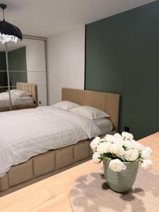 um quarto com uma cama e um vaso de flores em Sage Studio em Drobeta-Turnu Severin
