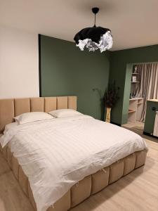 uma cama grande num quarto com uma parede verde em Sage Studio em Drobeta-Turnu Severin