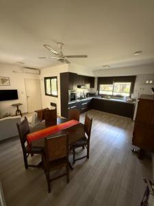 a living room with a table and chairs and a kitchen at Barrio Privado - YB - Tucumán in Yerba Buena