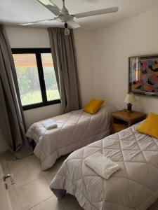 a bedroom with two beds and a ceiling fan at Barrio Privado - YB - Tucumán in Yerba Buena