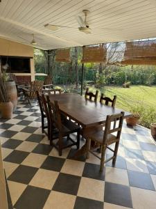 a large wooden table and chairs on a checkered floor at Barrio Privado - YB - Tucumán in Yerba Buena +4 photos