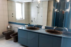 ein Badezimmer mit zwei Waschbecken, einer Toilette und einem Spiegel in der Unterkunft BeB Gallozzo in Cesate + 18 Fotos