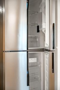 LYNS HOME في سولدن: ثلاجة فارغة وبابها مفتوح في مطبخ