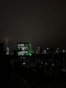 a city skyline at night with green lights at No.4 Residence in Warsaw