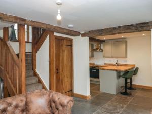 a kitchen with a stairway leading into a living room at Howgill Head in Kendal