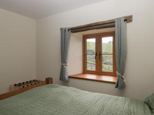 a bedroom with a bed and a window at Howgill Head in Kendal